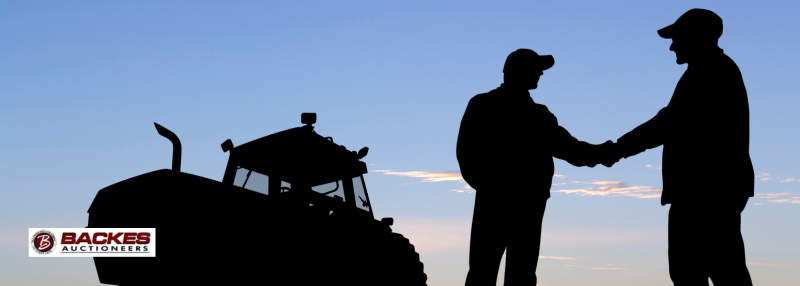 Image for Silhouette of two men shaking hands with a tractor in the background