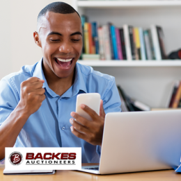 Image for Happy young man holding his phone and raising a fist due to excitement 